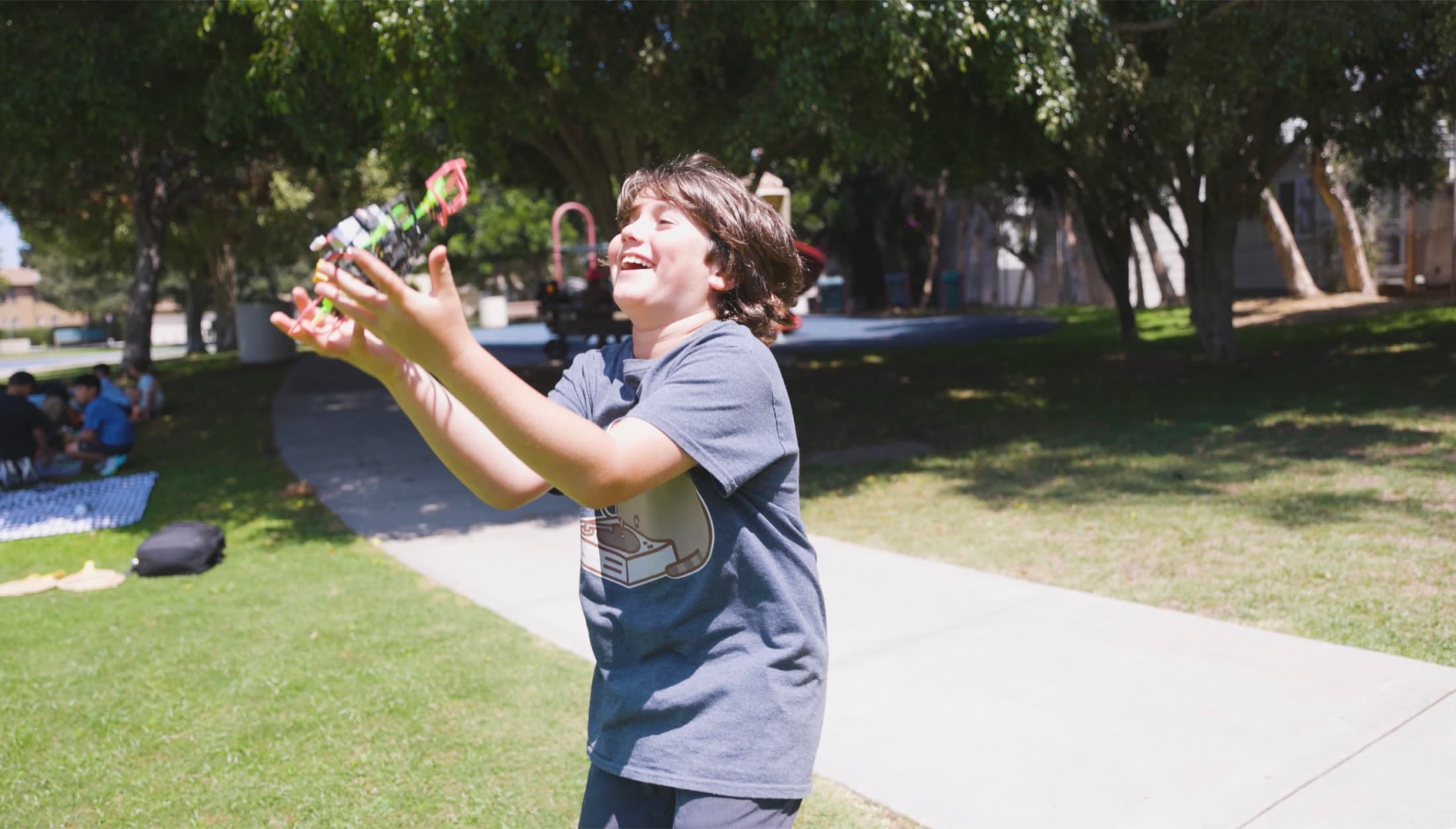 A camper laughing and playing outdoors at Gandara Park near Forge.