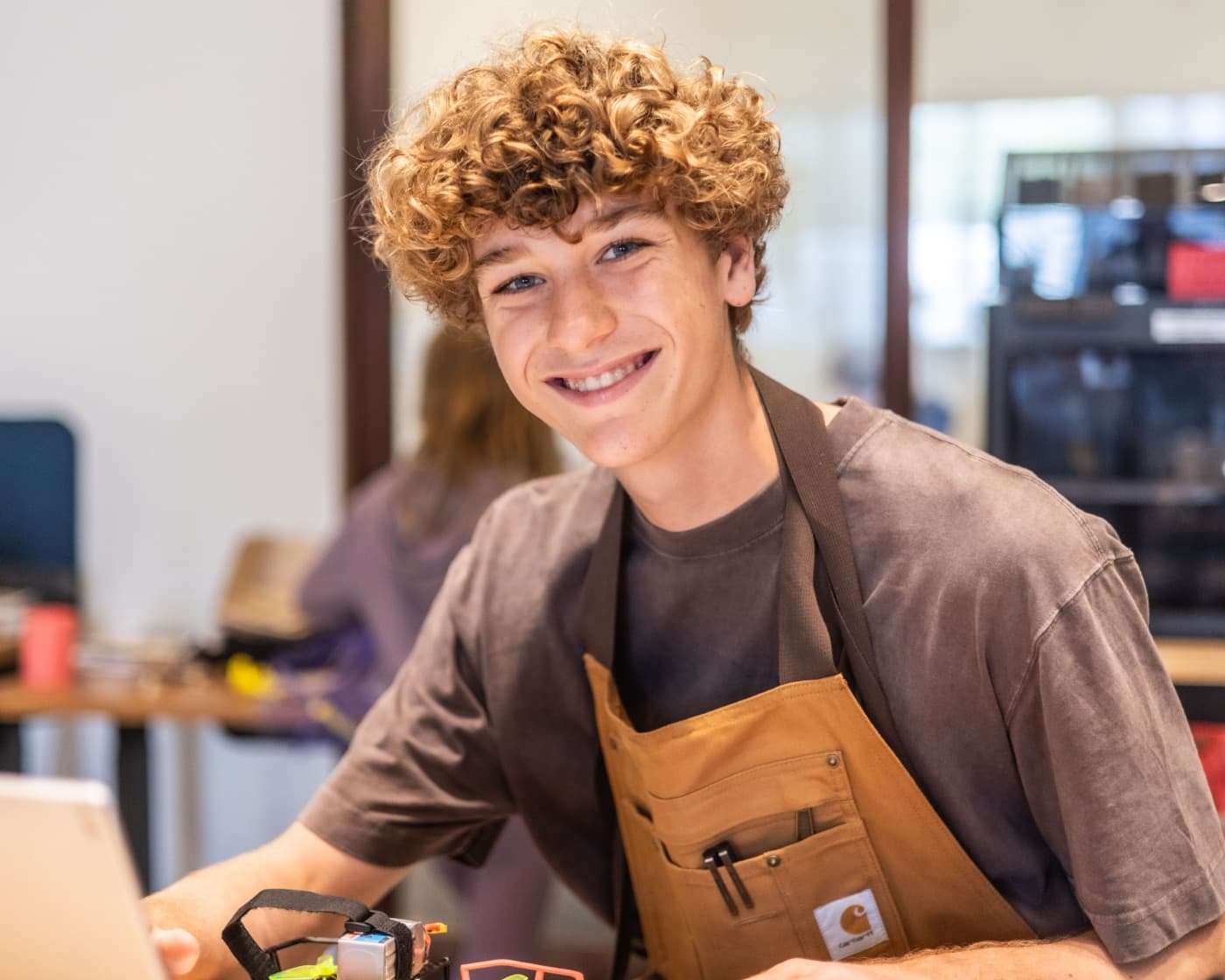 A teenage Forge counselor-in-training at the workbench.