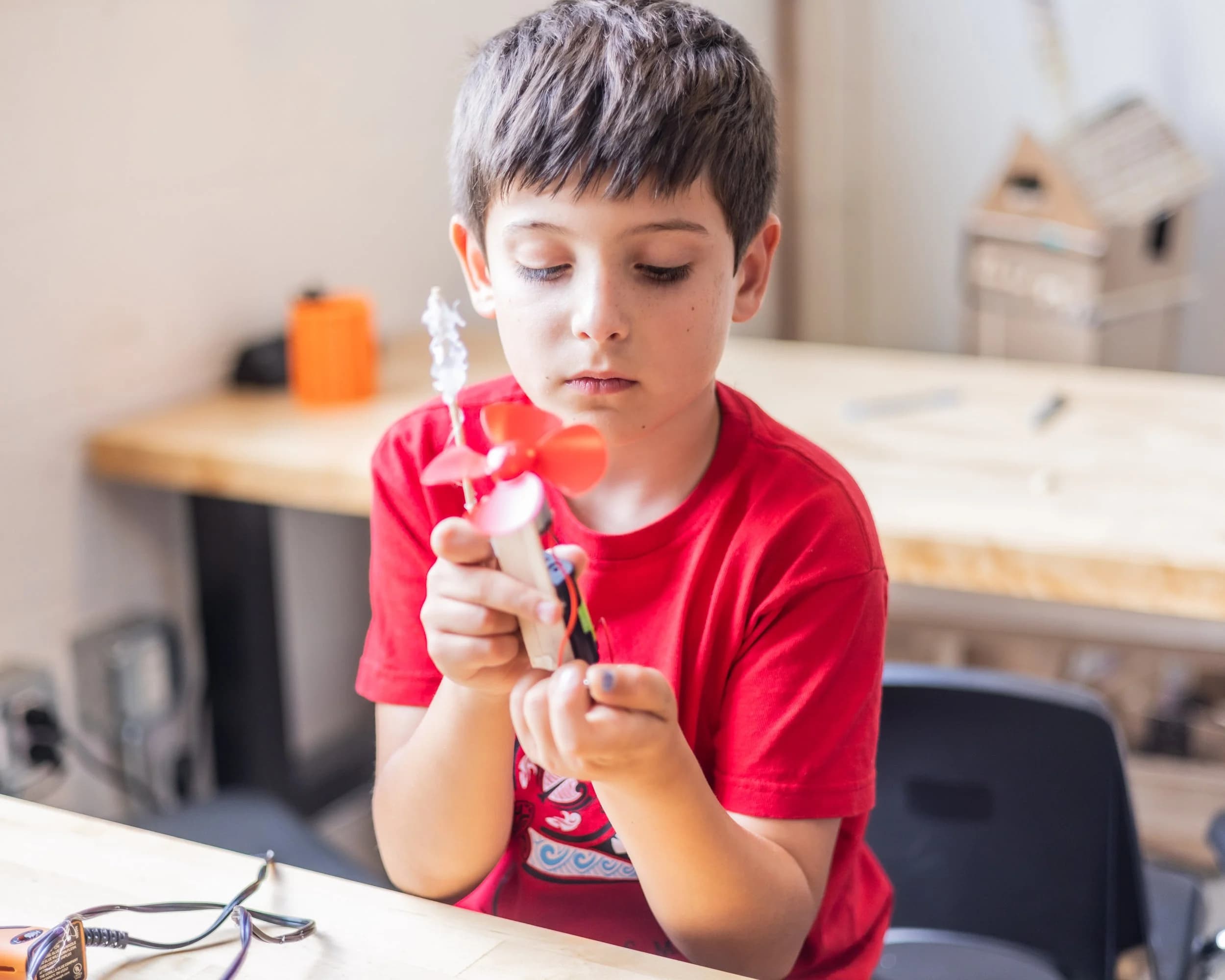 Forge students gathered around a workbench during a birthday party project.