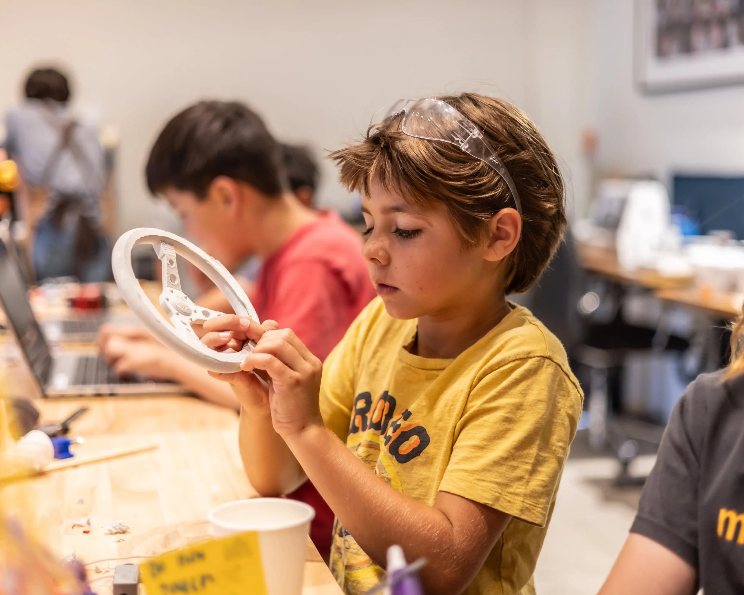 An older Forge student helping younger campers with a build.